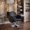 Female client seated in Globalstar BX-3010 black leather salon chair while stylist blow-dries hair in modern luxury salon
