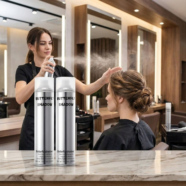 Hairdresser applying hair product to a client in a salon setting with Butterfly Shadow hair spray bottles.