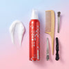 Hair care products including a can of foam, comb, and hair styling tools on a gradient background