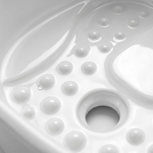 Close-up of a glossy white molded surface with raised circular bumps and a central circular opening, likely part of a product detail shot.