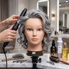 Student practising French braid technique on Globalstar 613/1B grey mannequin training head at Matrix cosmetology academy training station with ring light