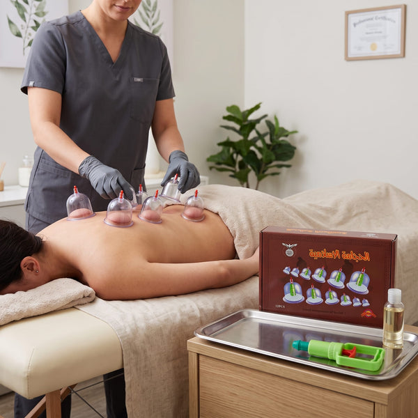 Professional therapist performing Hijama cupping therapy on client's back using Black 12-piece cupping set in certified wellness clinic