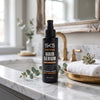 SK5 Fortifying Hair Serum 120ml bottle on marble bathroom counter with eucalyptus and white towel