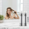 Woman styling her hair in front of a mirror with two bottles of 'Butterfly Shadow' products on a marble surface.