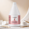 Female client with pink manicured nails resting on towel beside Globalstar Nail Polish Remover 3.78L with silver cuticle tools and cotton pads at professional nail salon station