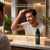 Man styling healthy thick hair in luxury bathroom mirror with SK5 Fortifying Hair Tonic 200ml on counter